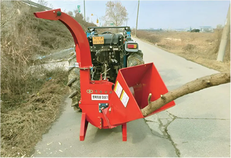 Feeding a thick branch into ORATEXCA GK7 WCT wood chipper